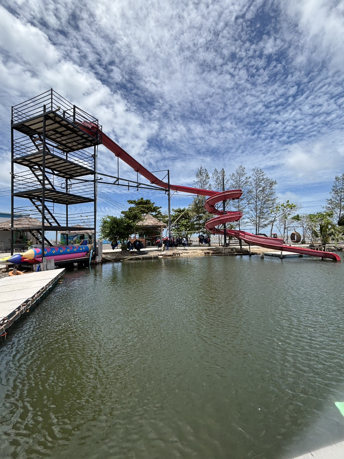 สไลเดอร์สีแดงขนาดใหญ่ริมบ่อน้ำที่ Aloha Sunset